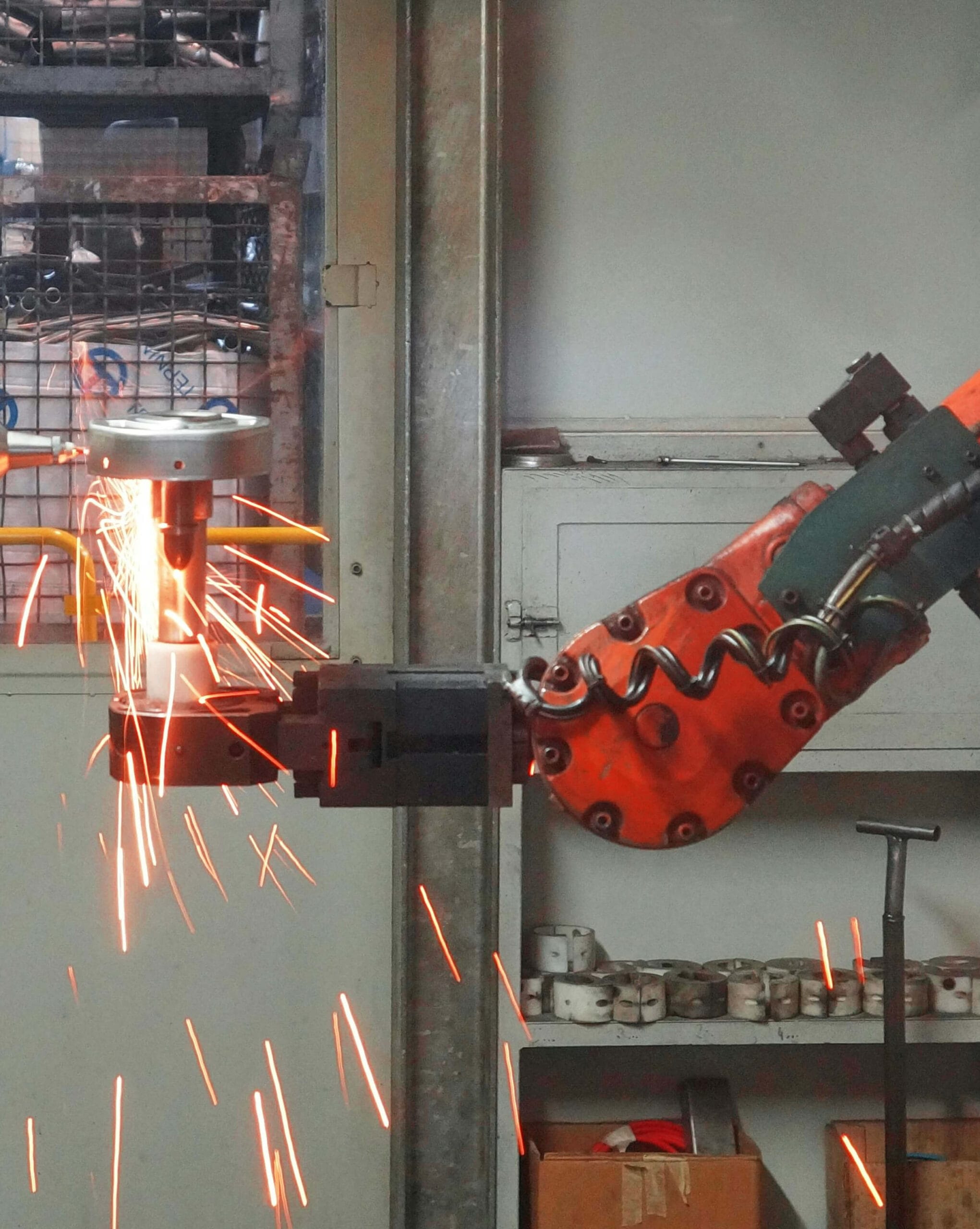 Industrial robot arm grinding metal with sparks flying